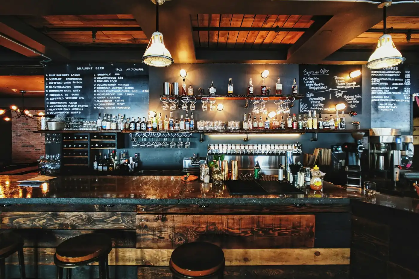Dva elegantní nealkoholické drinky ozdobené bylinkami na barovém pultu s mosaznou deskou.
